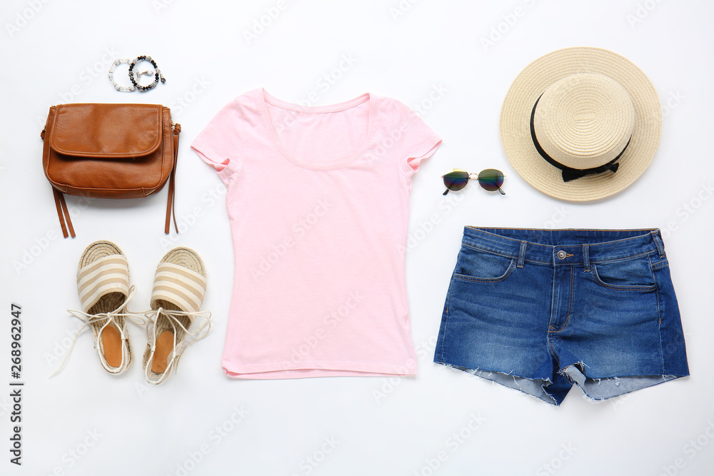 Stylish female clothes with accessories on white background