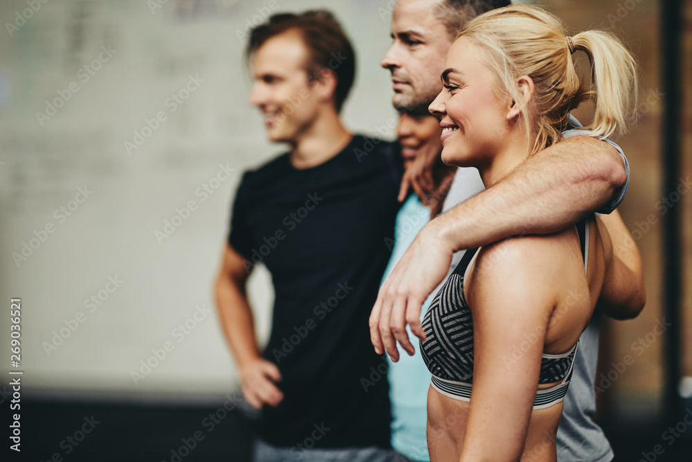 Diverse friends smiling while standing in a gym together