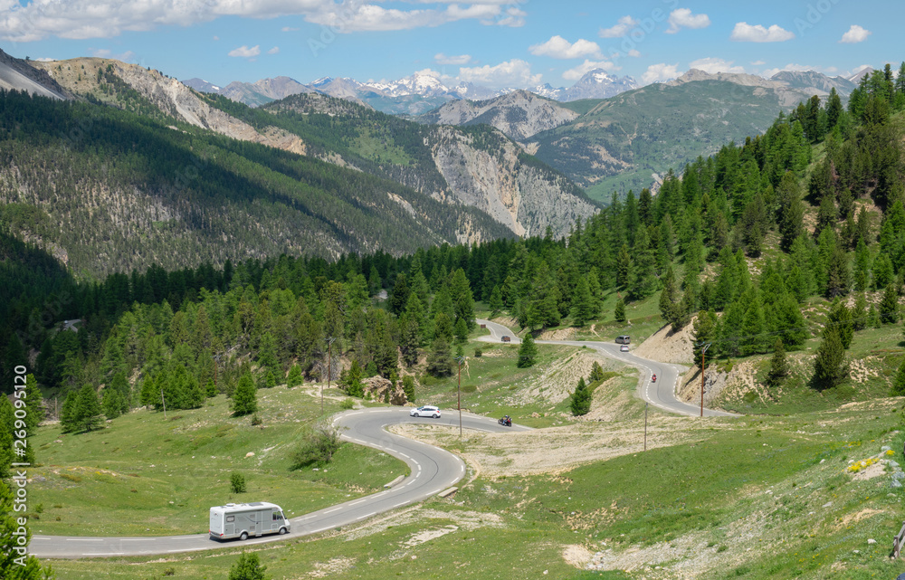 航空：公路旅行的游客沿着欧洲阿尔卑斯山蜿蜒的道路行驶。