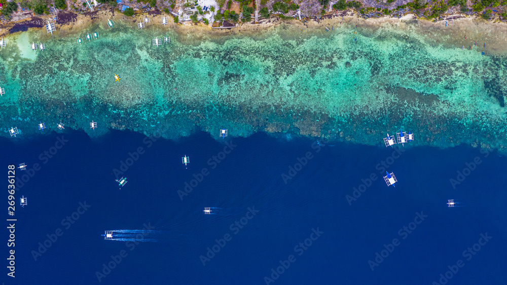 菲律宾船只漂浮在清澈的蓝色水面上的鸟瞰图，莫阿尔巴尔是一个清澈的蓝色海洋