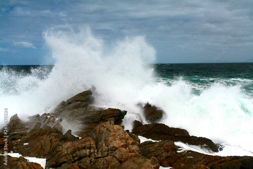 Waves crashing on the rocks, region of Pringle Bay. In the distant background, the Cape of Good Hope