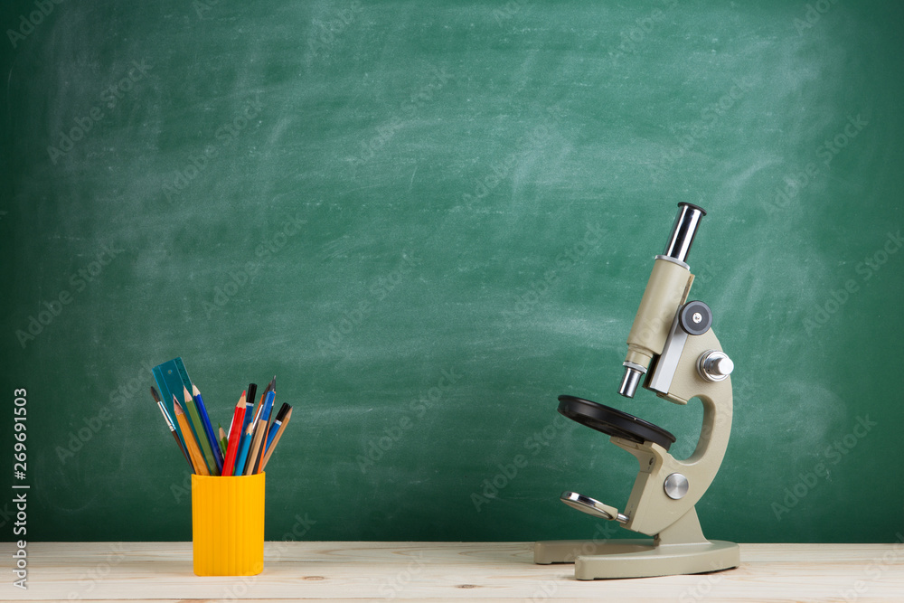 教育理念——礼堂桌子上的显微镜，黑板背景