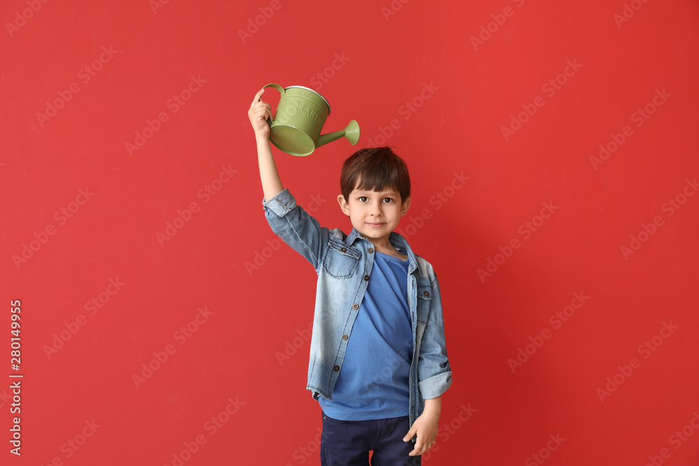 小男孩带着彩色背景的喷壶。儿童成长的概念