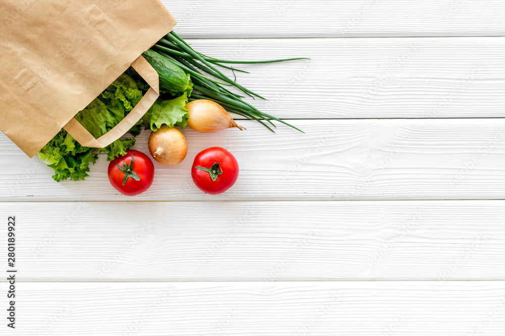 白色木质背景纸袋中的新鲜蔬菜的健康食品俯视图空间用于文本