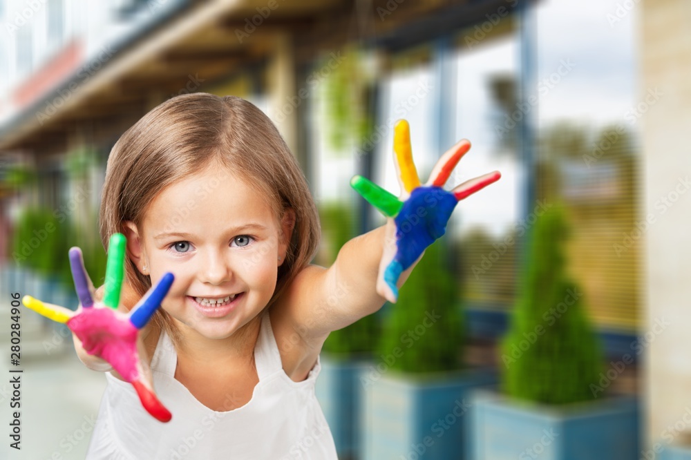 Cute little girl with colorful painted hands on  background