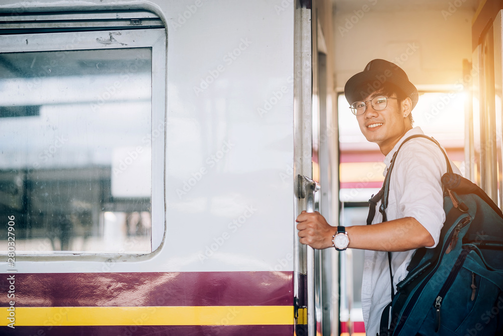 Asian man is traveler, he is waiting for their train. Outdoor adventure travel by train concept. Ban