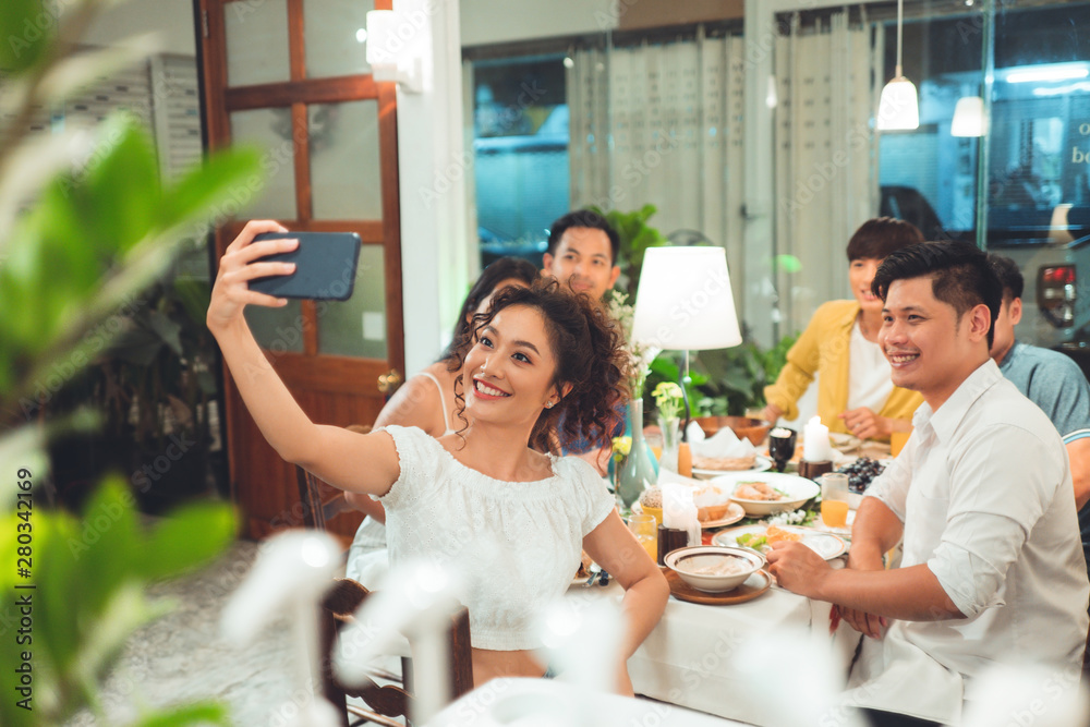 Group friends asian are taking selfies while eating dinner.