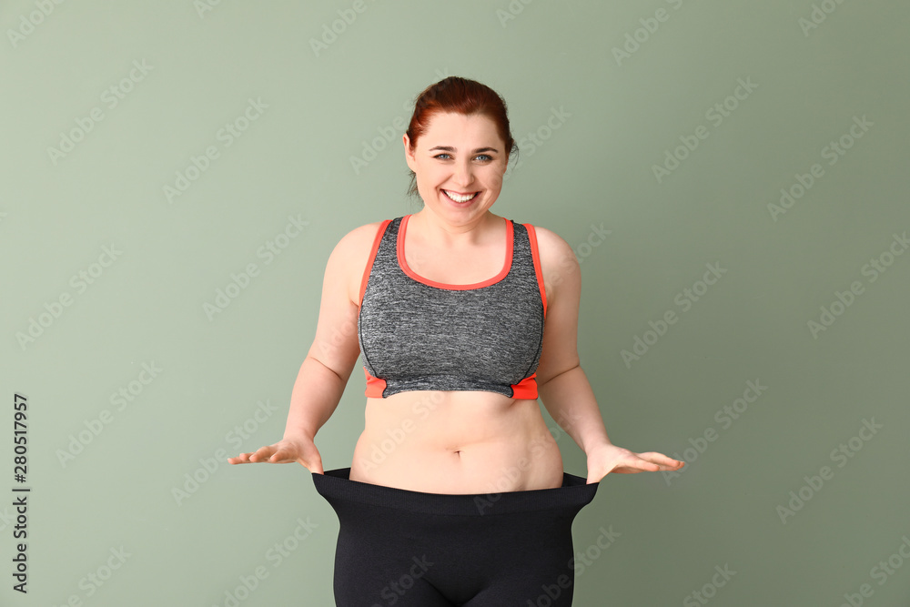 超重女性穿着宽松的彩色背景衣服。减肥概念