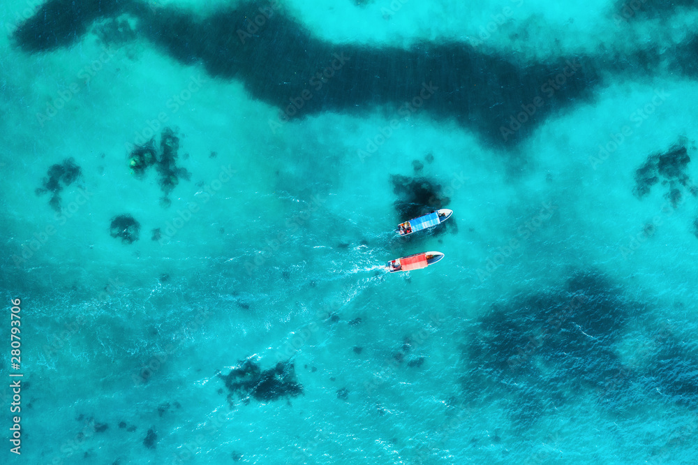 夏季日落时，透明蓝色水中渔船的鸟瞰图。无人机俯视图