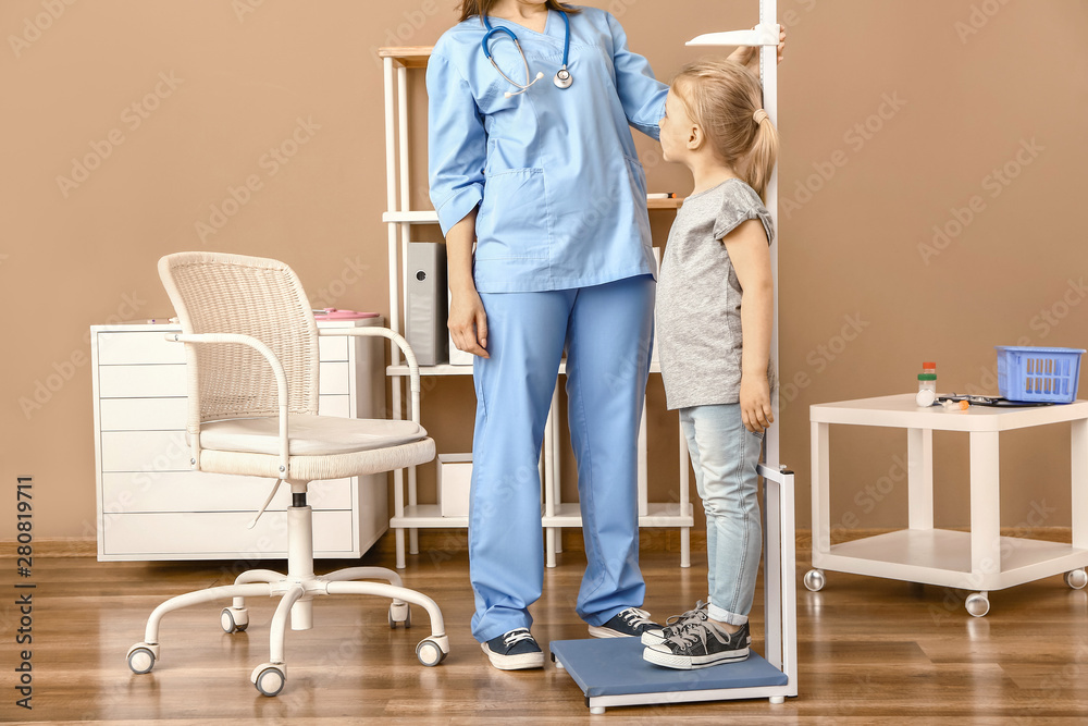 女护士在医院测量小女孩身高