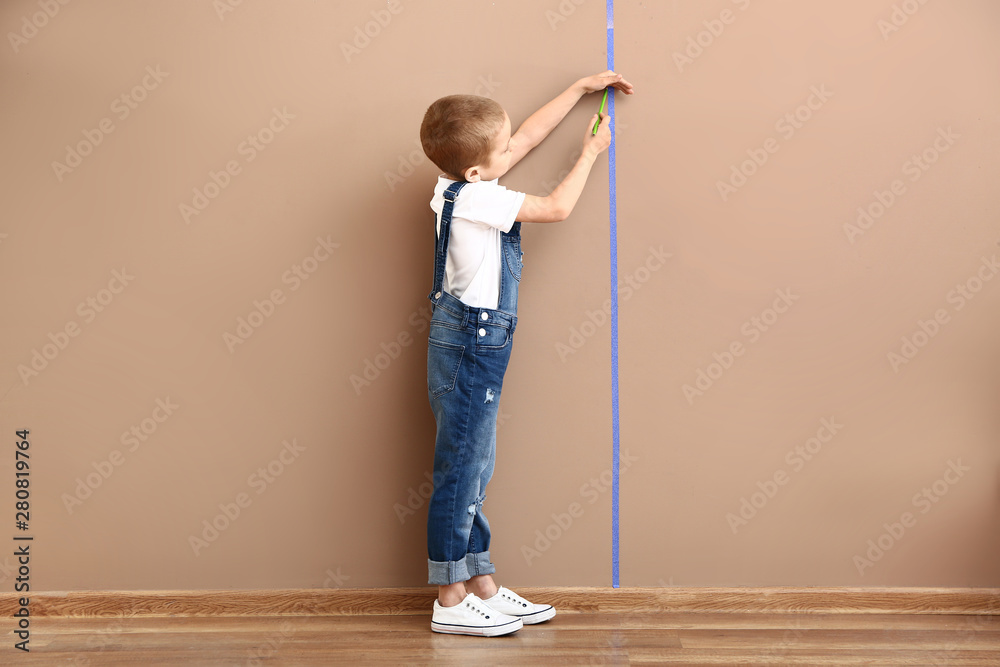 小男孩在墙附近测量高度