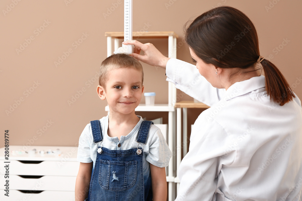 女医生在医院测量小男孩身高