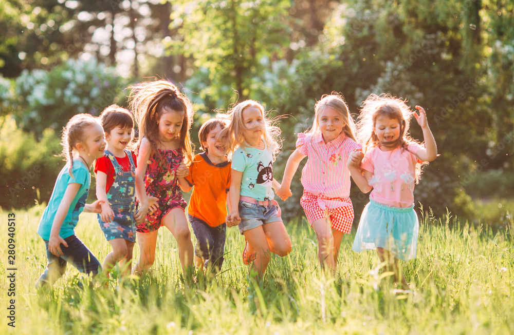 阳光明媚的夏日，一群孩子、朋友、男孩和女孩穿着休闲服在公园里奔跑