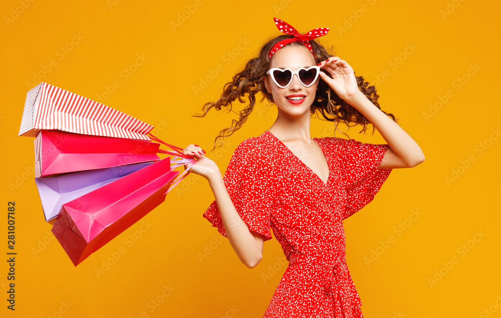 黄色背景包裹快乐女孩的购物购买和销售概念。