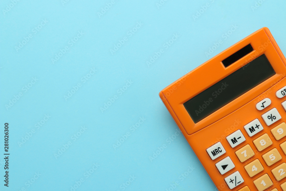 Orange calculator on a bright blue paper background. Office supplies. Education. back to school. top