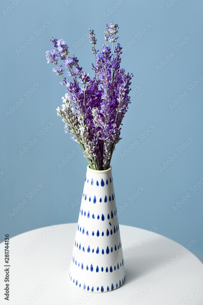 桌上花瓶里美丽的淡紫色花朵，背景为彩色