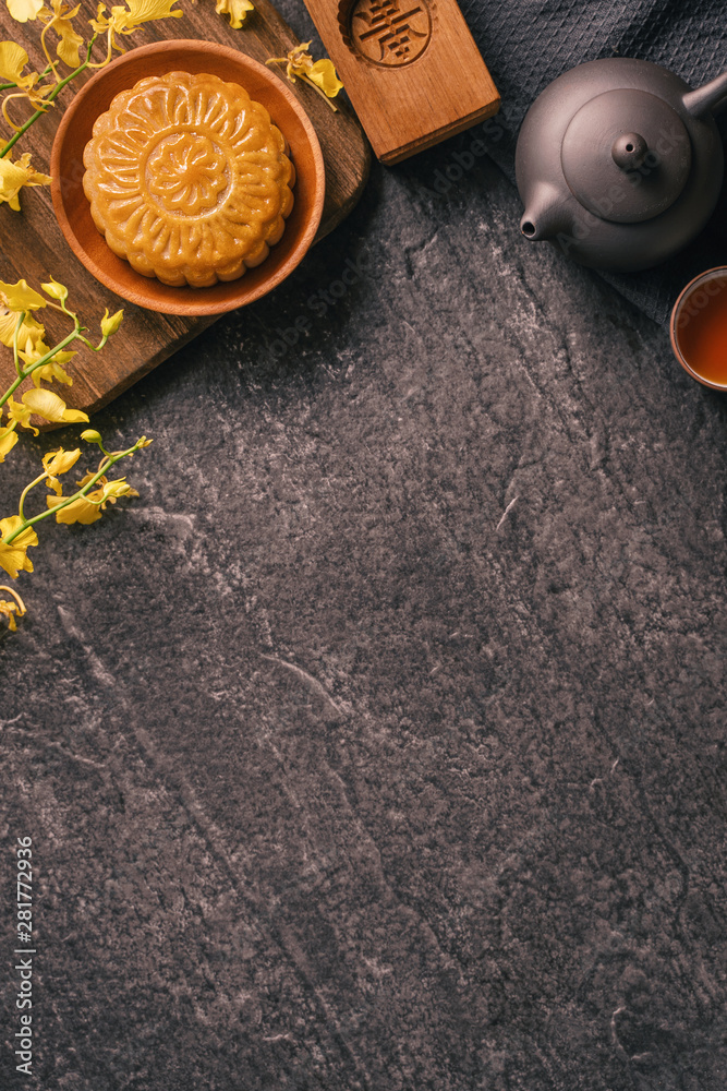 中秋节传统美食理念-黑石板桌上的漂亮月饼配茶，啪