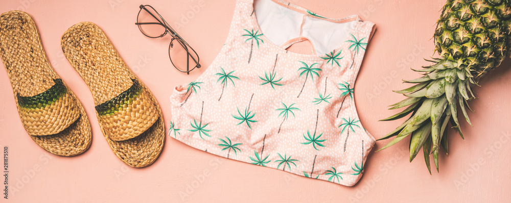 夏季服装。平躺的夏季人字拖、太阳镜、手掌图案的粉色比基尼上衣