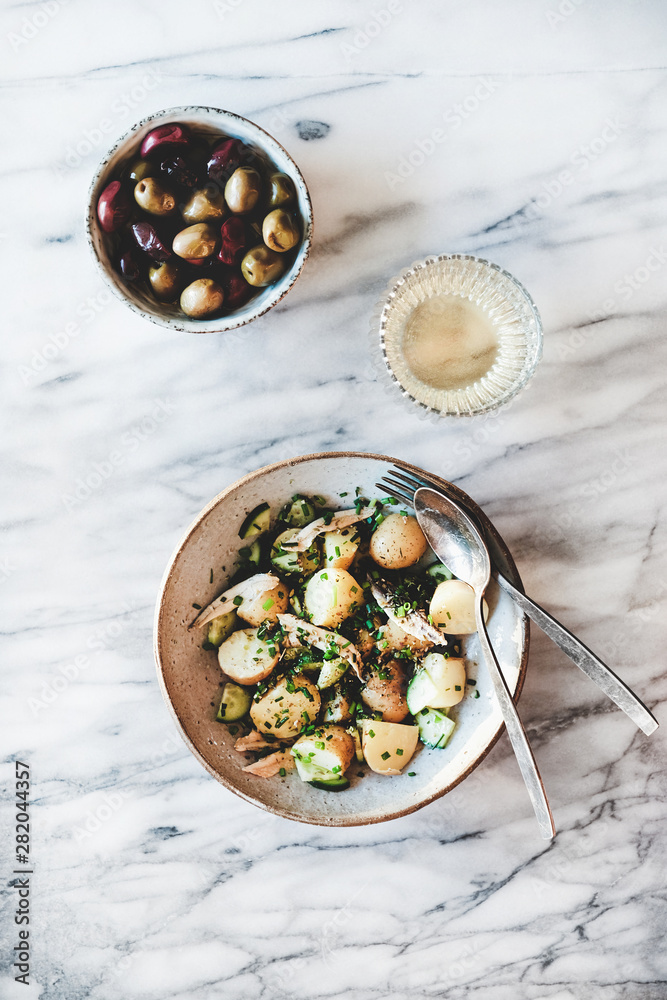 健康清淡的夏季午餐。希腊风格的土豆沙拉配腌凤尾鱼、韭菜、黄瓜和o
