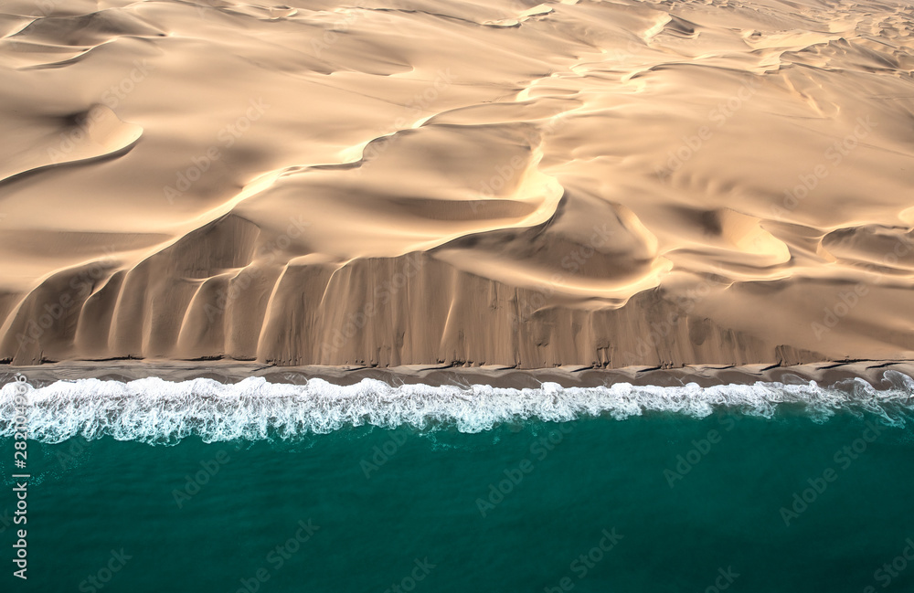 骷髅海岸沙丘与大西洋海浪交汇的鸟瞰图。纳米比亚骷髅海岸