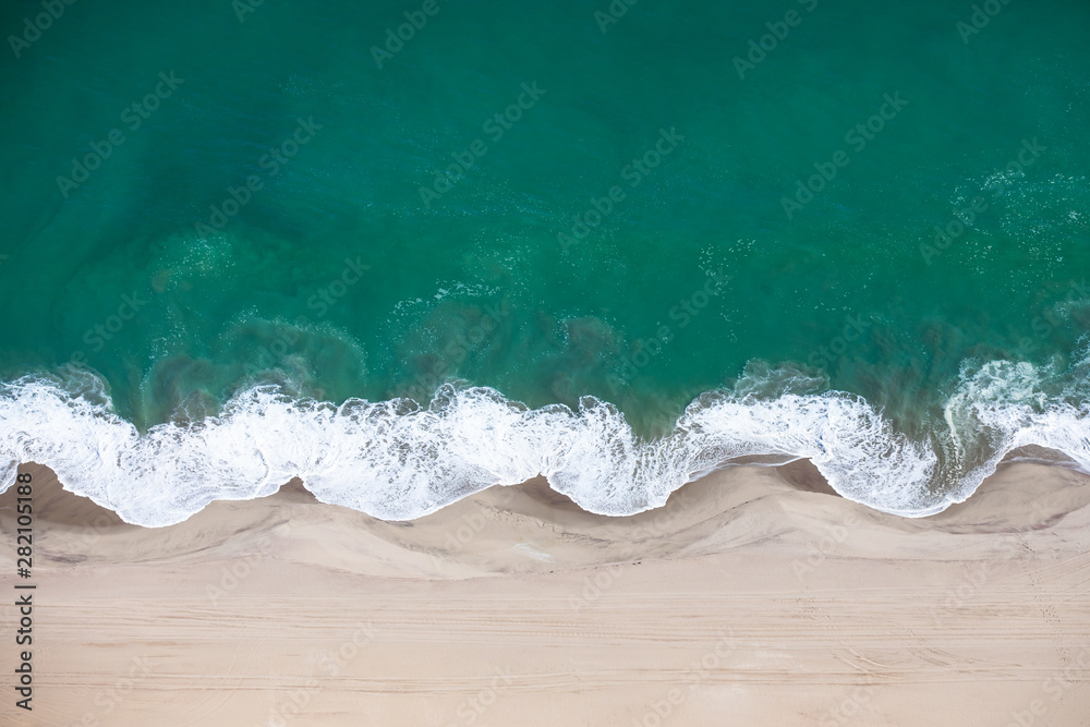 骷髅海岸沙丘与大西洋海浪交汇的鸟瞰图。纳米比亚骷髅海岸