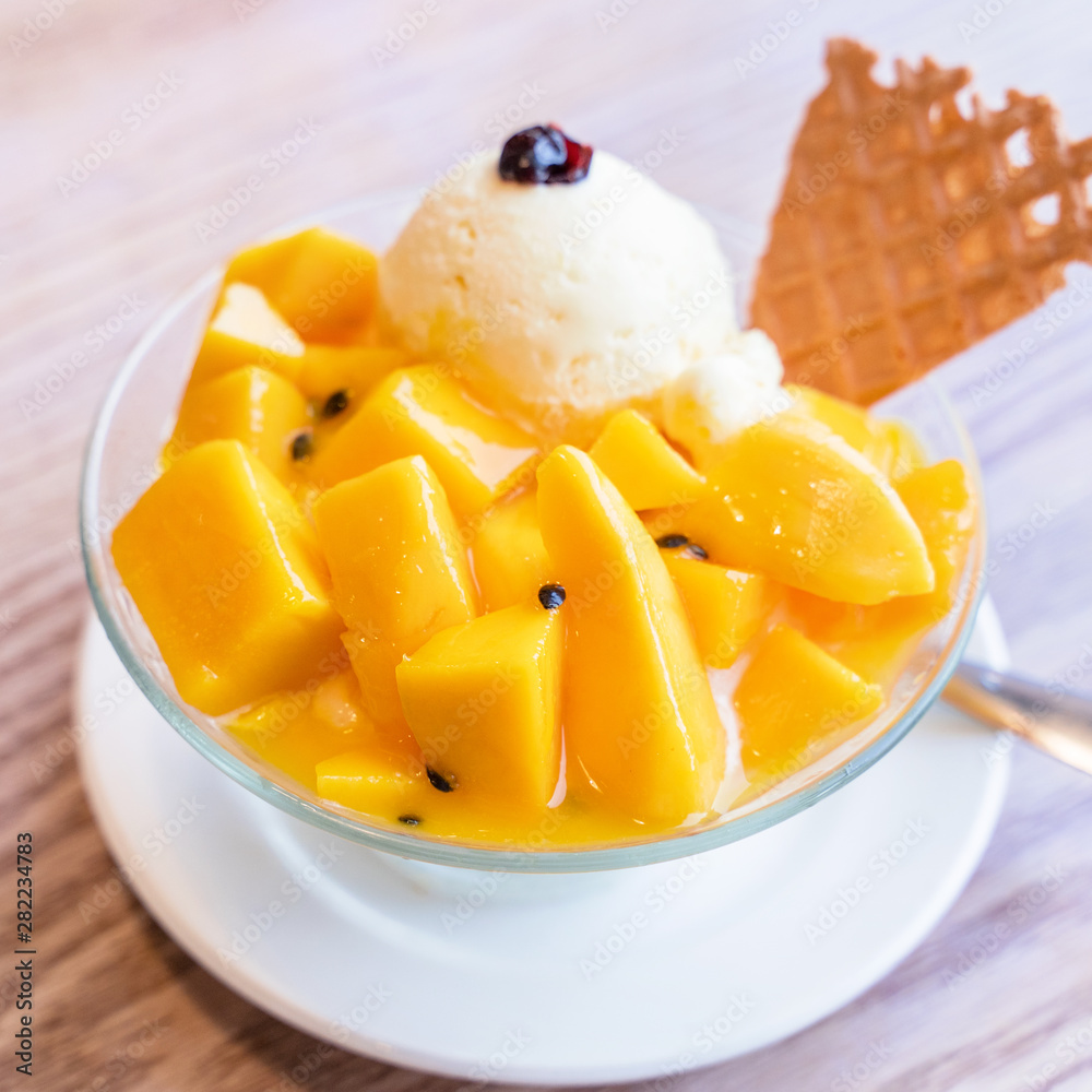 夏季餐厅，生活方式，po中的新鲜芒果刨冰加一勺冰淇淋和果汁酱