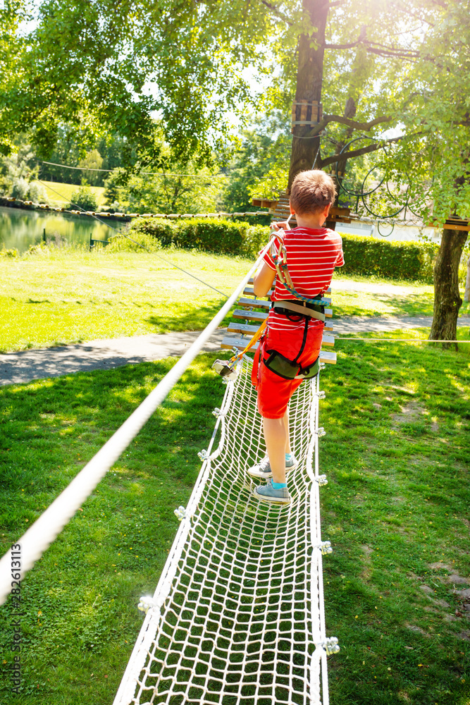 夏日公园里的小男孩走过伸展的网