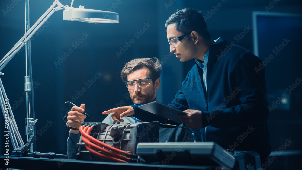 Two Professional Automotive Engineers with a Tablet Computer and Inspection Tools are Having a Conve