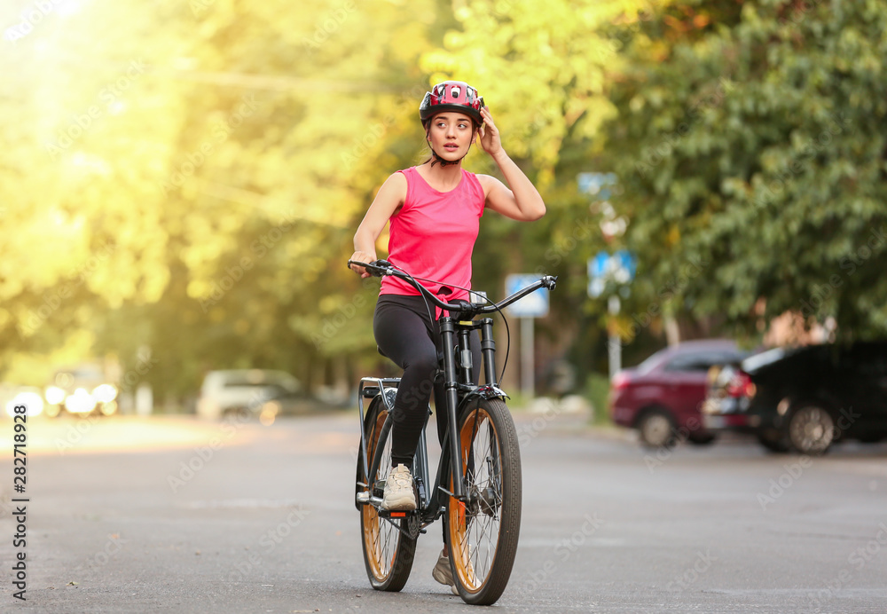 运动型年轻女子在户外骑自行车