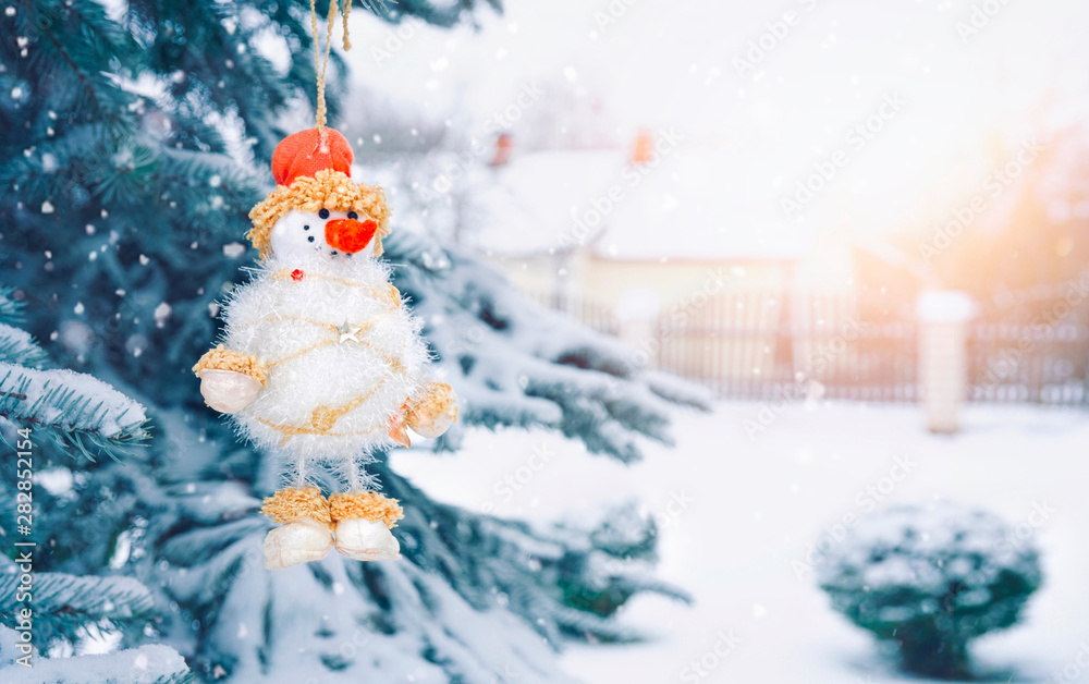 雪人在白雪覆盖的圣诞树上，户外有复制空间。