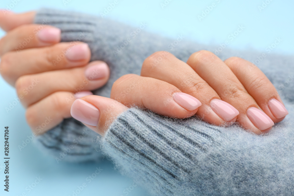 在彩色背景上修指甲的女人的手，特写