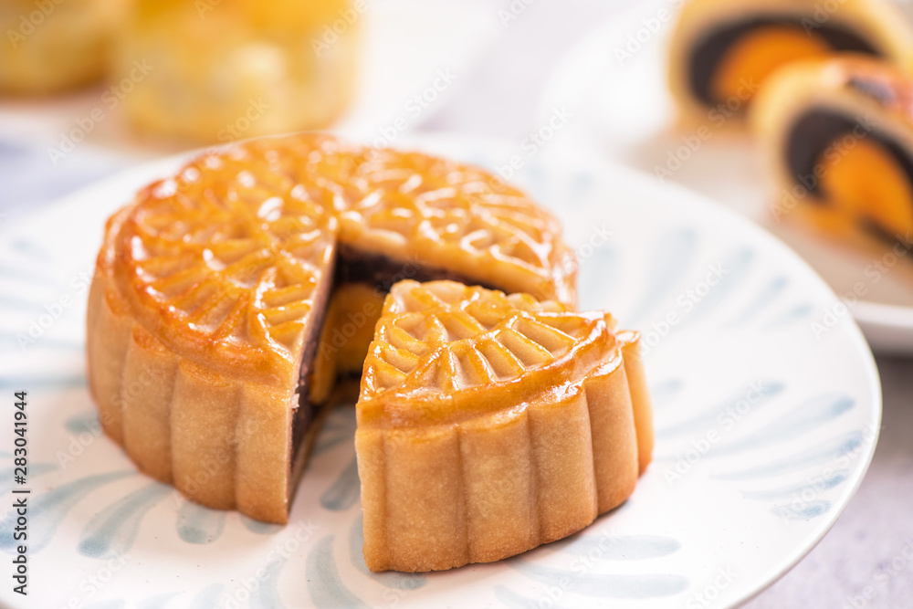 中秋节传统美食理念-惠特蓝纹板上切得漂亮的月饼