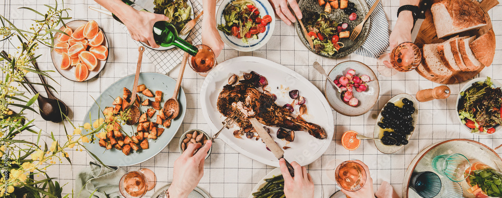 家人或朋友聚在一起吃晚餐。吃羊肩肉、沙拉、蔬菜的人平躺在地上