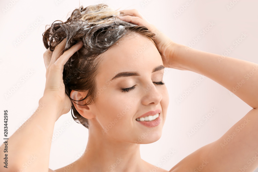 美丽的年轻女子在淋浴时洗头