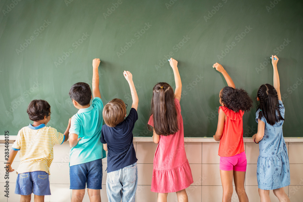 多民族学童在黑板上画画