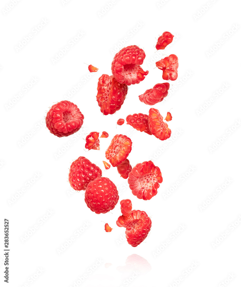 空气中的整颗和切片树莓，在白色背景上隔离