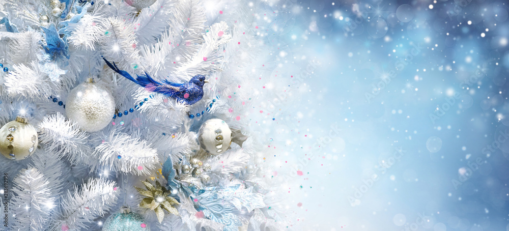 白色圣诞树上装饰着银色金色的圣诞球和美丽的蓝色小鸟祝你好运