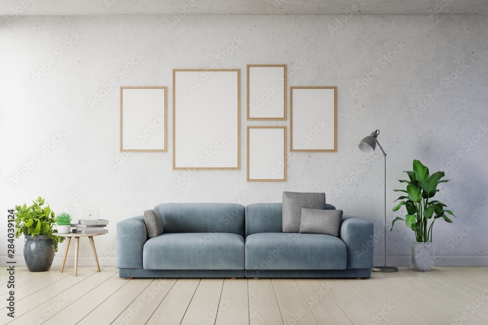 客厅室内白色墙壁上的垂直框架海报模型和深蓝色沙发。