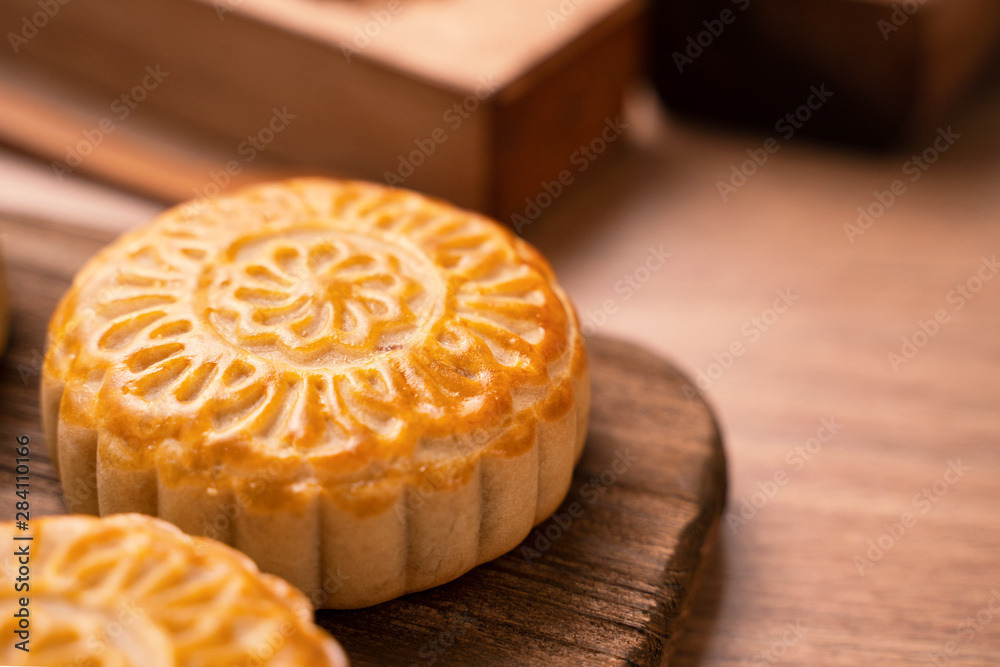 Round shaped fresh baked moon cake pastry - Chinese moonckae for Mid-Autumn Moon Festival on wooden 