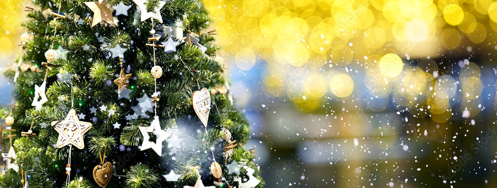 圣诞树上装饰着星星的木质花环，在一个模糊的、闪闪发光的夜晚黑暗的ba上