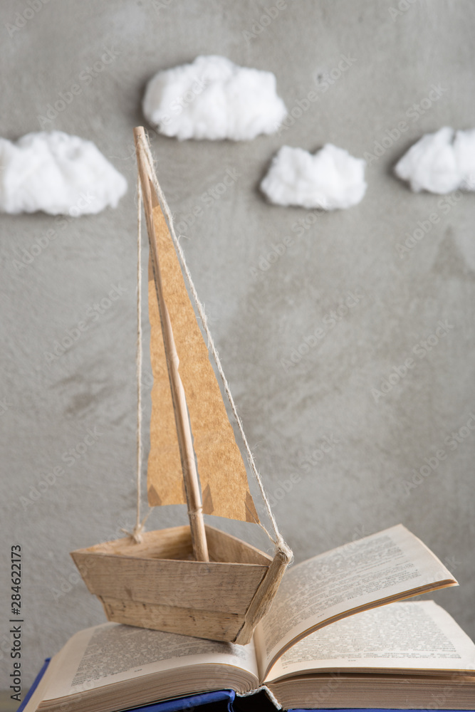 教育是一个旅程概念，玩具船和书籍就像木桌上的海浪，灵感