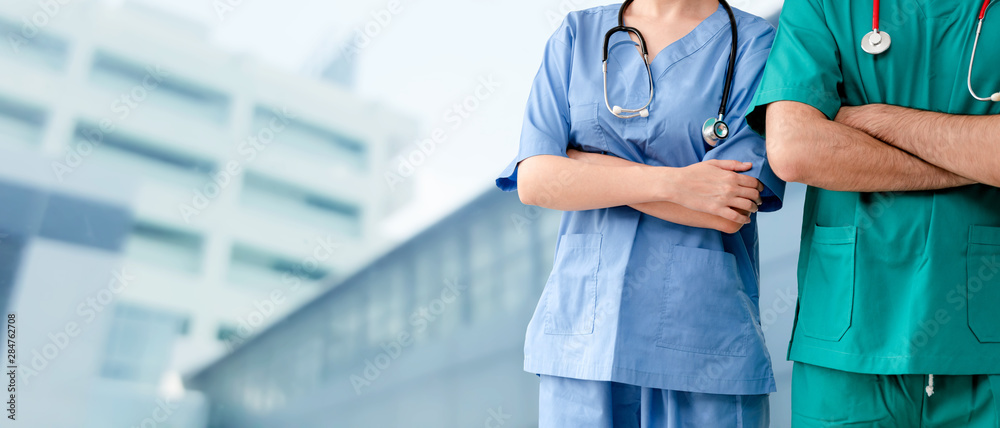 两名医院工作人员-外科医生、医生或护士站在医院里，双臂交叉。医疗h