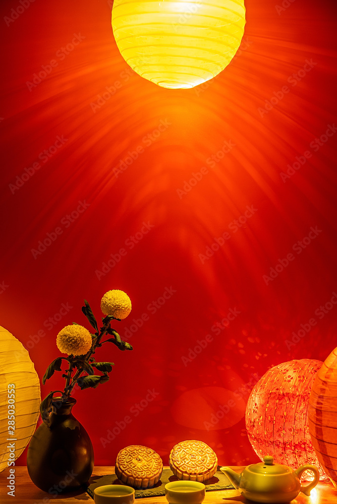 Mid-Autumn mooncakes and tea under colorful lantern lights in red background