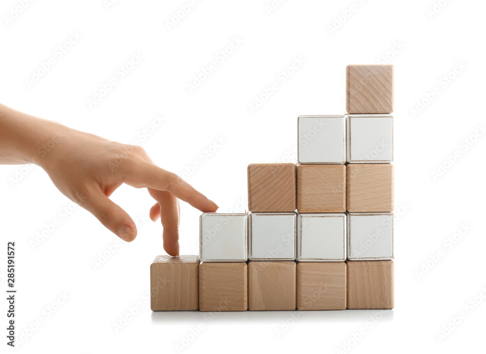 堆叠的立方体和在白色背景下模仿上楼的女性手。进步的概念