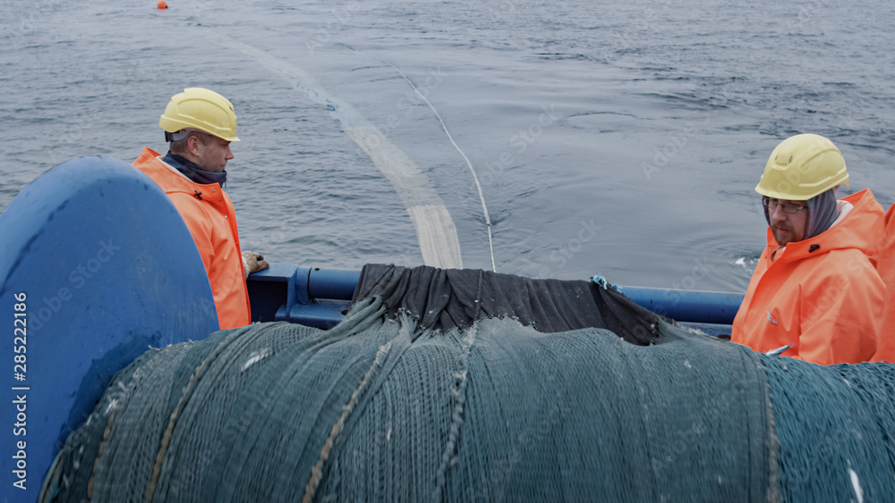 渔民团队在商业捕鱼期间解开拖网。