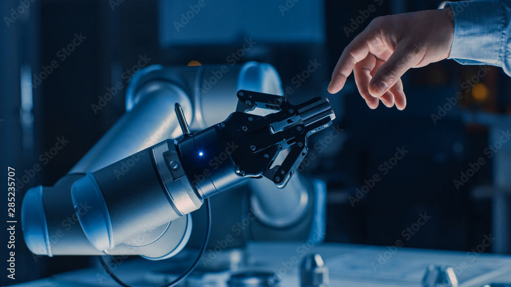 未来主义机器人手臂在人类和人工智能统一手势中触摸人手。Co