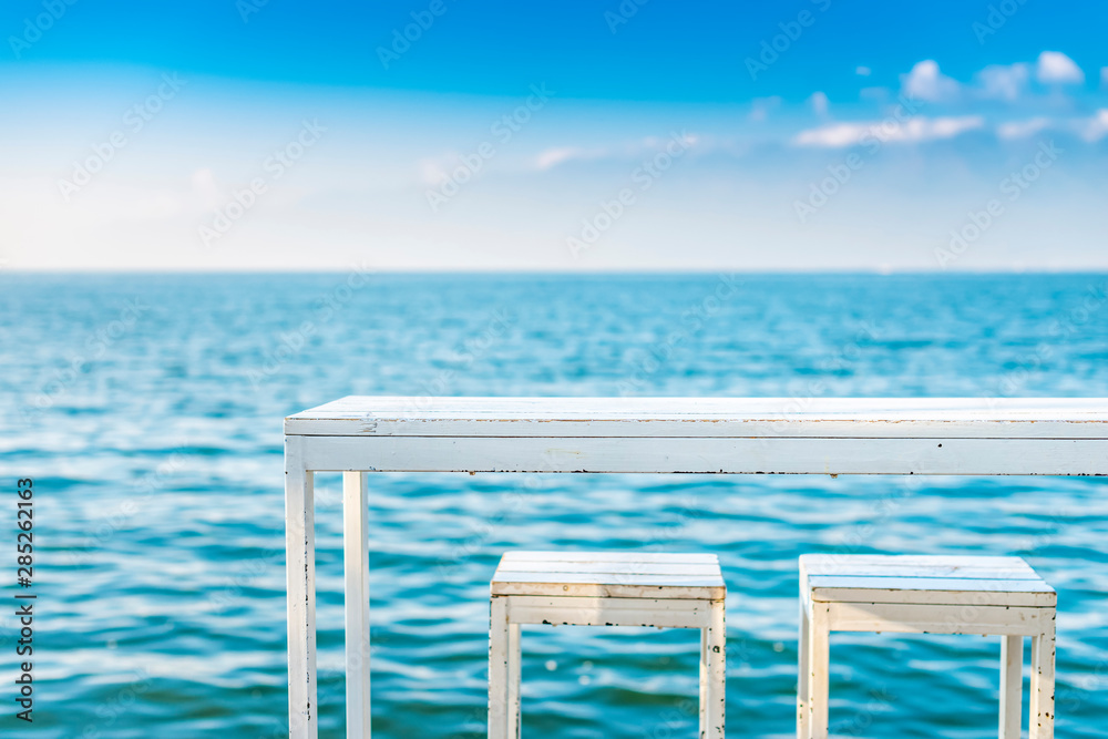 蓝色湖面上的白色桌椅。位于中国云南大理洱海。