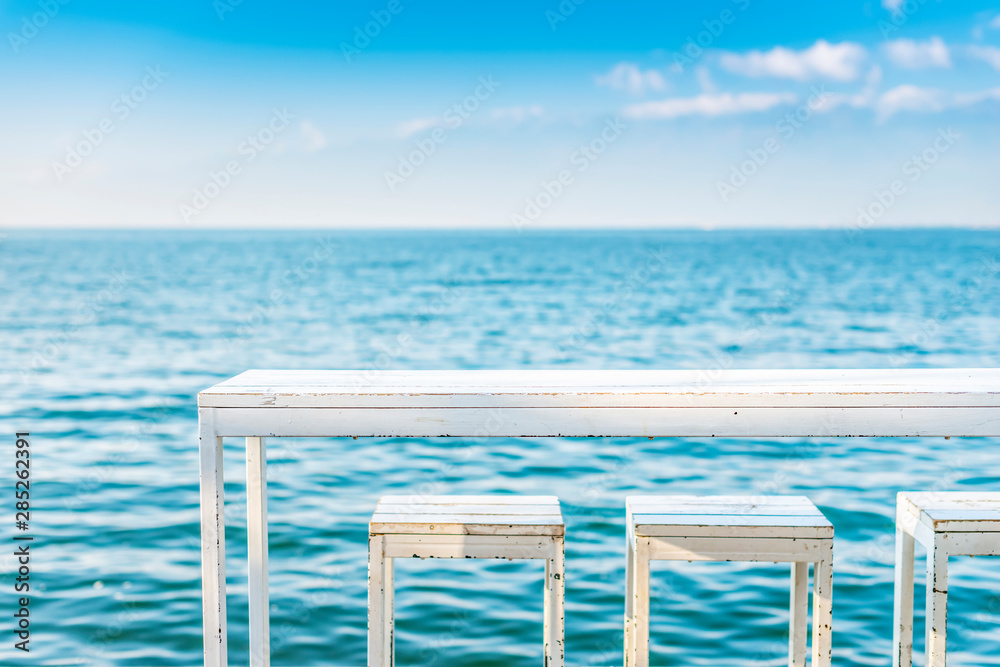 蓝色湖面上的白色桌椅。位于中国云南大理洱海。