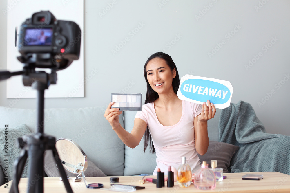 Asian beauty blogger announcing giveaway while recording video at home