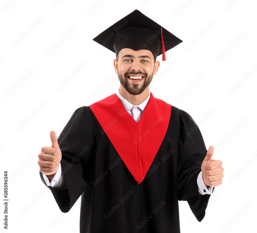 身穿学士长袍的年轻男学生在白底上竖起大拇指